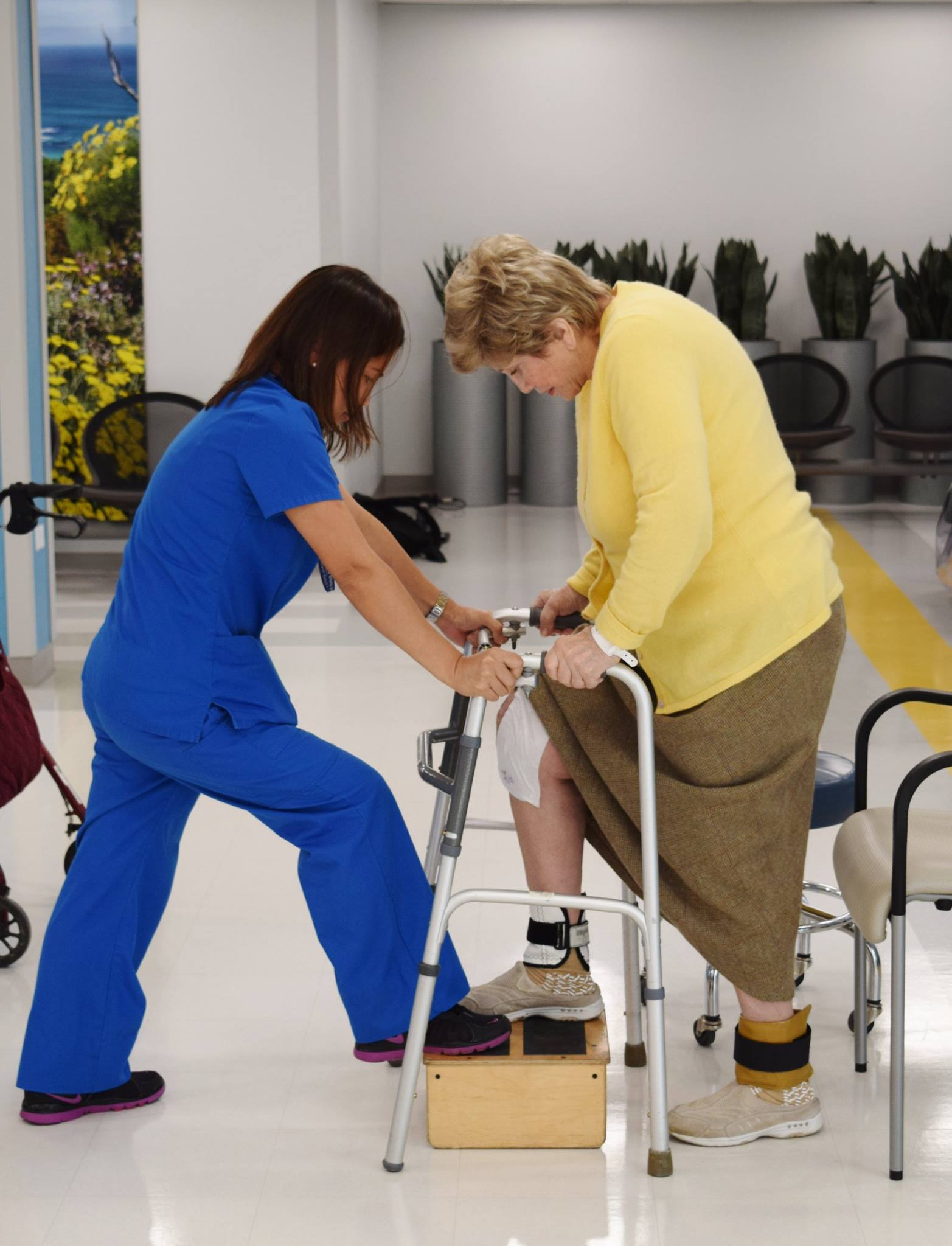 Nurse assisting female patient in using a walker at Upper East Side Rehabilitation and Nursing Center.