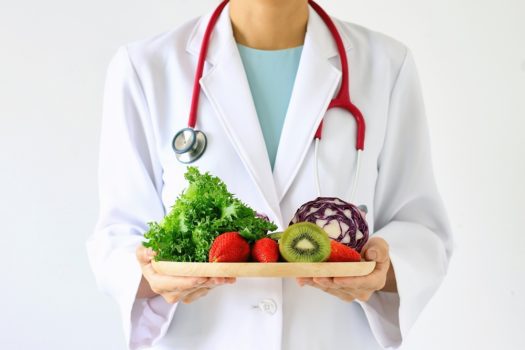 Doctor holding fresh fruit and vegetable, Healthy diet, Nutrition food as a prescription for good health.